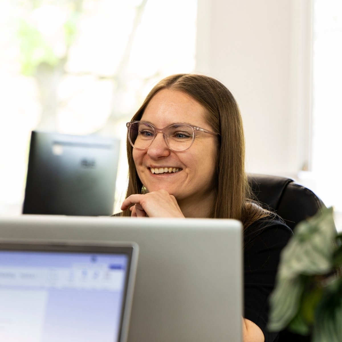 Team Photos - Archimedia Accounts - photo of a team member sat at her desk smiling with her team mate opposite