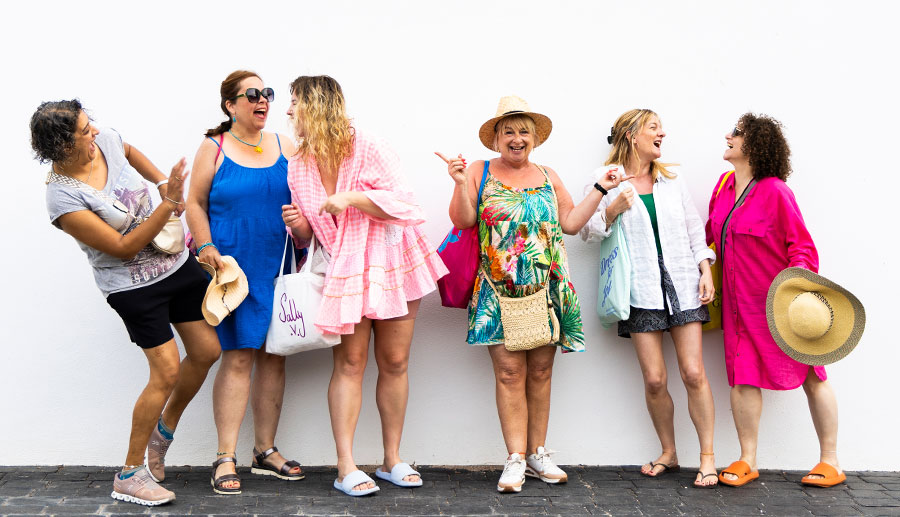 Six women wearing colourful summer outfits on a Women's Business Retreat in Mijas, Spain